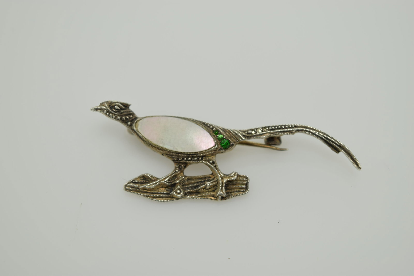 Sterling, MOP, and marcasite pheasant pin.: A small (2" x 1/2") marked sterling pin shaped as a pheasant with a mother of pearl center and marcasite. In good condition.