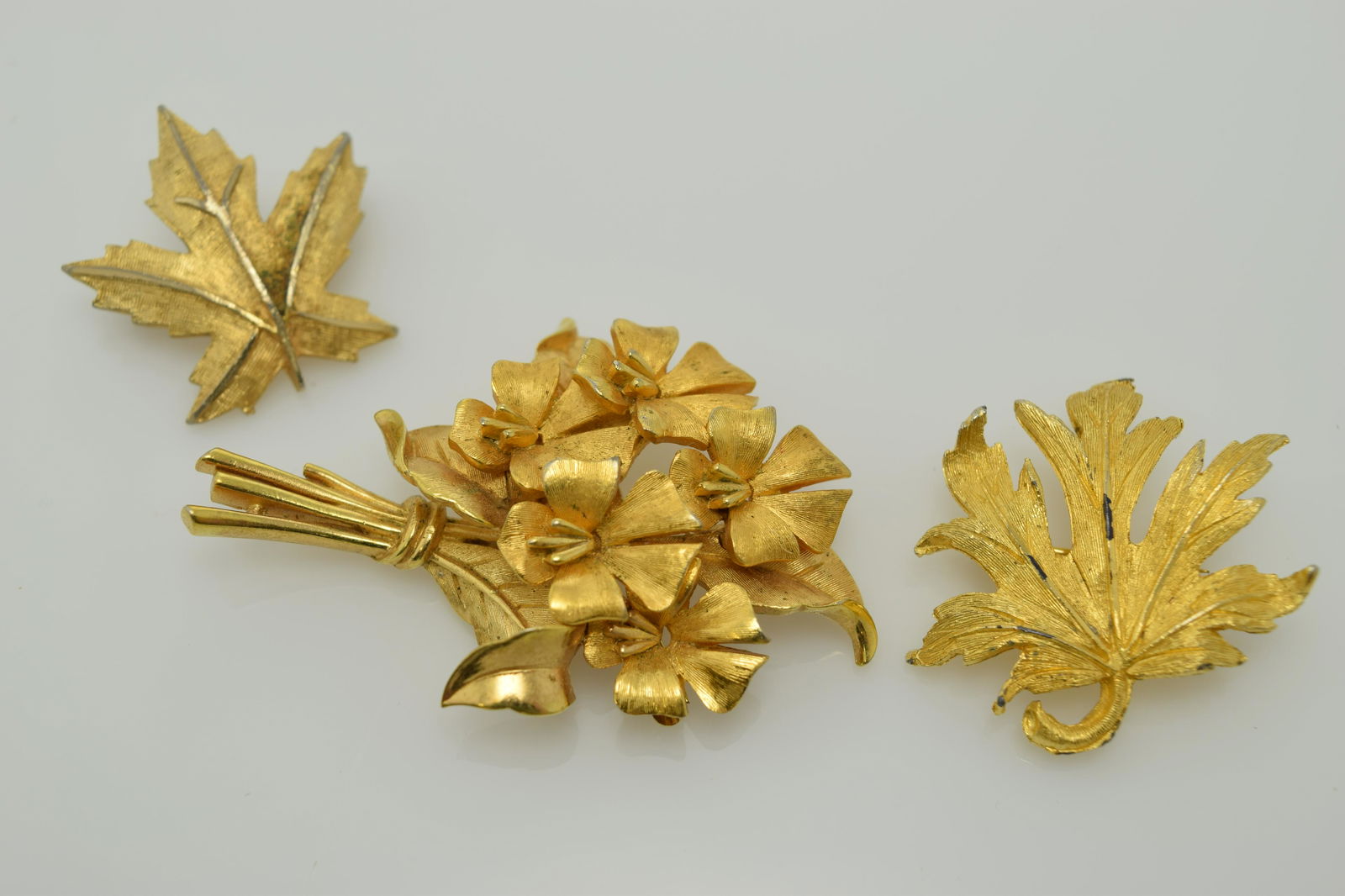 A lot of three gold tone pins. (1 of 2)