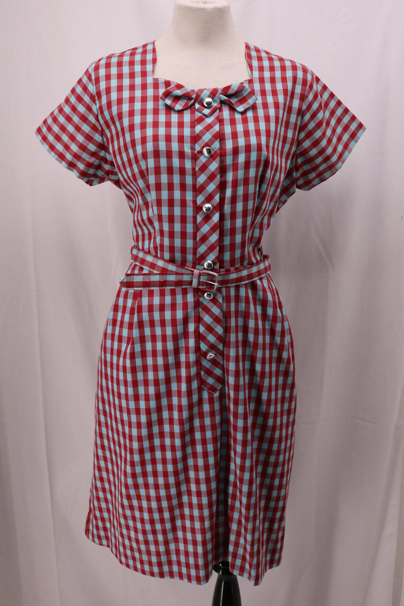 Vintage 1940's Red and Blue Gingham Shirt Waist Dress: short sleeves, square neck, button front to waist, bow and tie detail on front, cotton blend, red and blue gingham check, right slit pocket, matching fabric belt, Approx. 40" Bust, 34" Waist, pin dot 