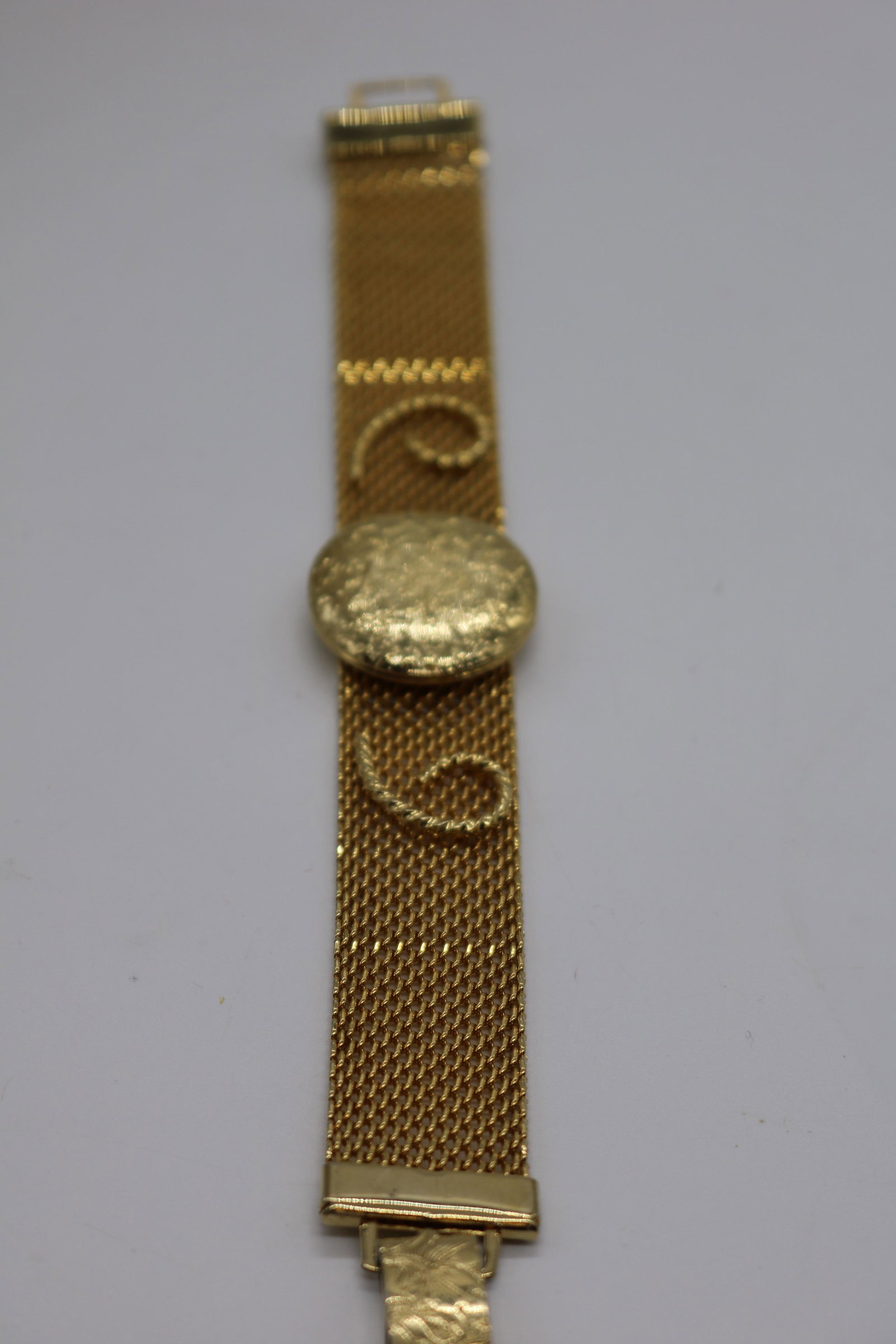 A vintage mesh bracelet with locket, signed Sarah: An approx. 7-1/2" x 3/4" vintage, gold tone mesh bracelet w 1" in diameter locket that opens to put photos in. Signed Sarah Cov. In good condition.