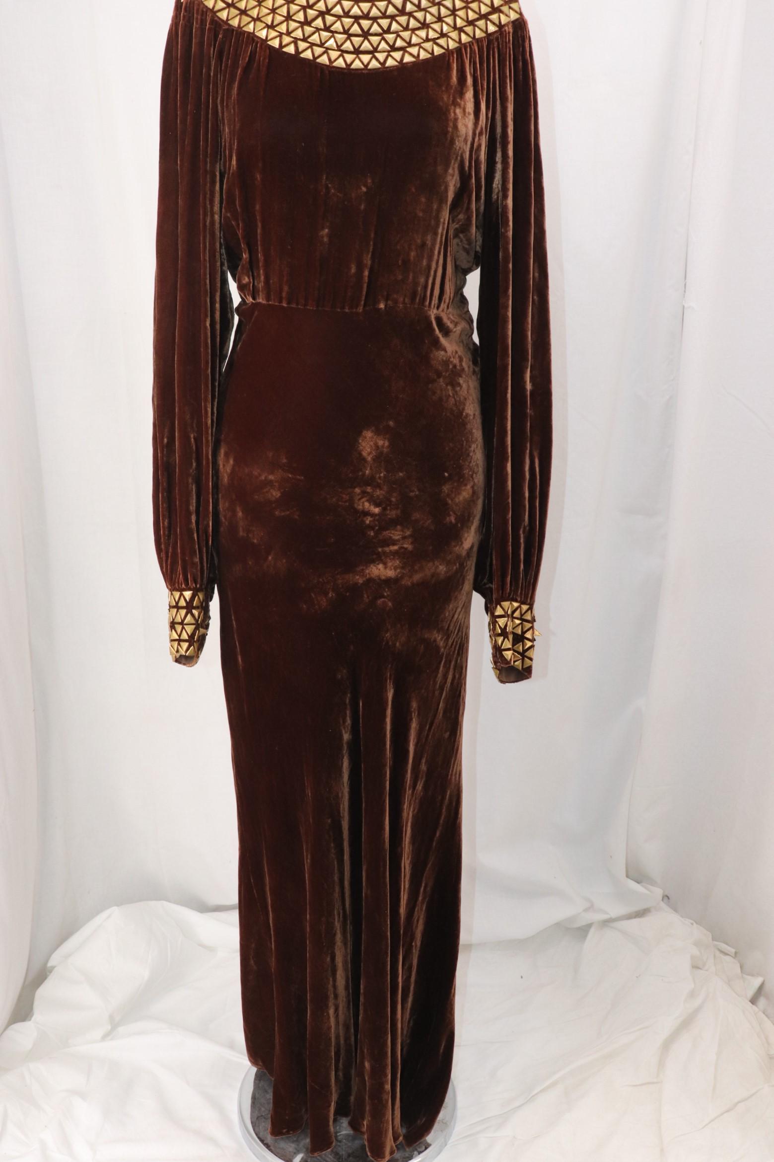 Vintage 1930's Triangle Studded Brown Velvet Gown: long wide sleeves with triangle studded cuffs with snap closure, smocked at shoulders, round neck with triangle studded detail, empire waist, vertical slits on back with bands of studs on either side,