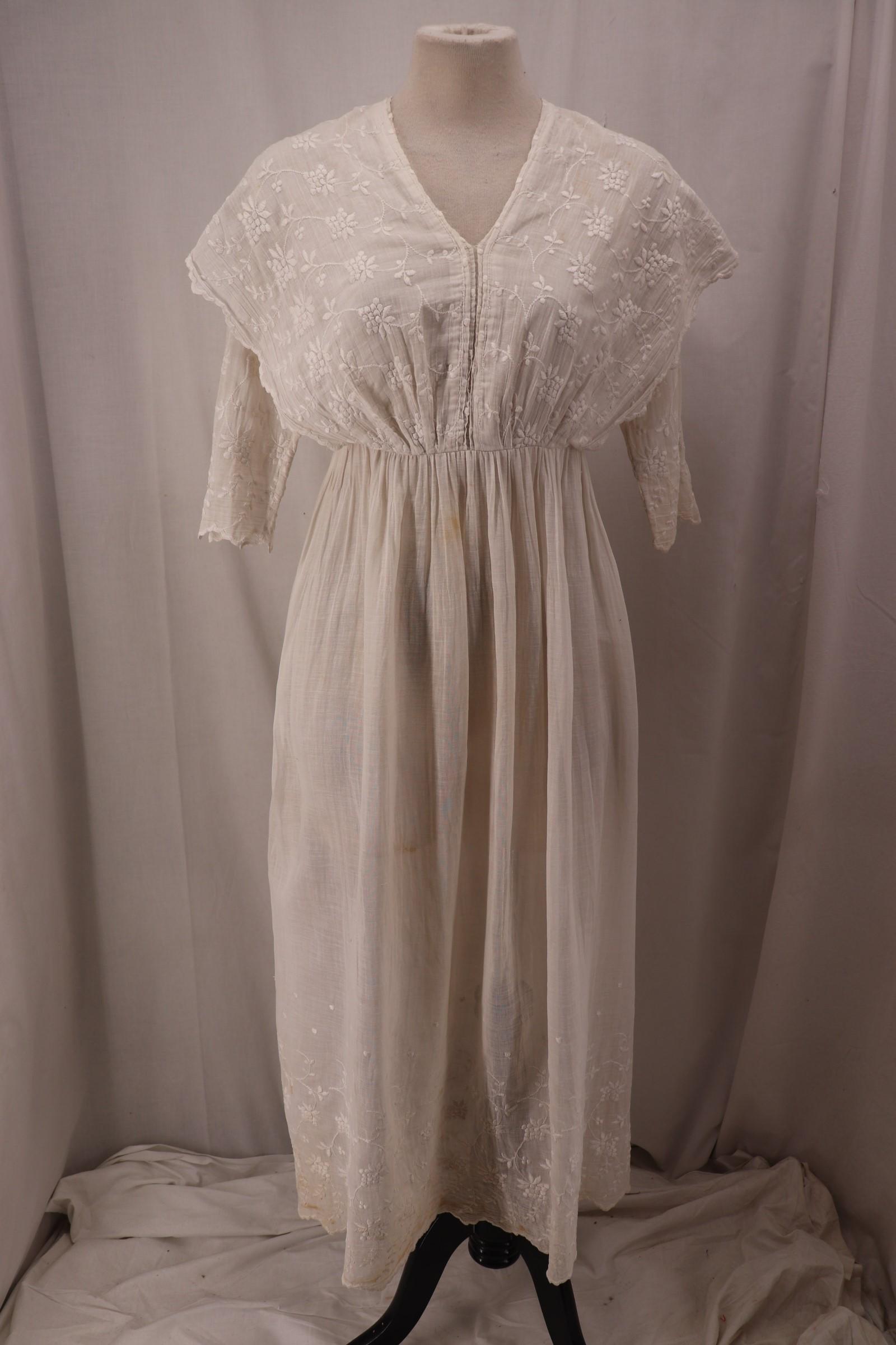Antique 1910's White Cotton Tea Dress: elbow length sleeves with scalloped cuffs and floral embroidery, V-neck, shawl style bodice with floral embroidery, high waist, skirt gathered at waist with floral embroidery and scalloped hem, button