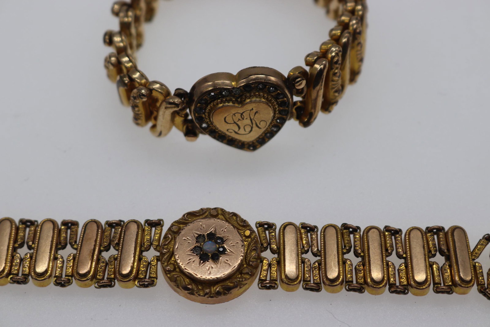 Lot of 2 Vintage Gold-Tone Stretch Bracelets: gold-tone stretch bracelets, one with monogram heart, "L.K.", with faceted stones, Approx. 6" (unstretched), other is round with etched snowflake/sun design with faceted and iridescent stones (bracele