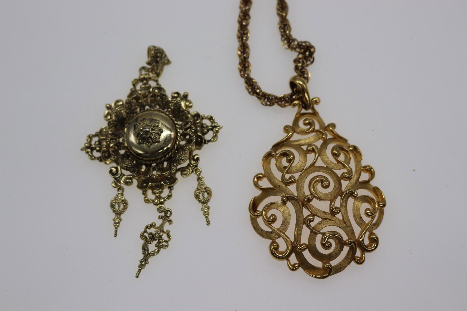 Lot of 2 Vintage Gold-Tone Pendants: Intricate gold-tone filigree locket, Approx. 4", scroll design pendant with chain, Pendant Approx. 2.5", Chain- Approx. 18", See photos.