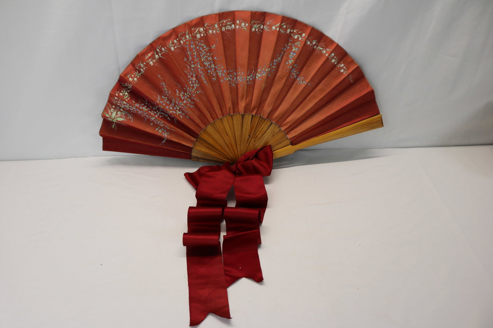 Antique wood ladies hand fan with silk hand painted flowers with large satin ribbon bow: approx. 13.5 inches, needs repair to the silk where it attaches to the wood, see photo's