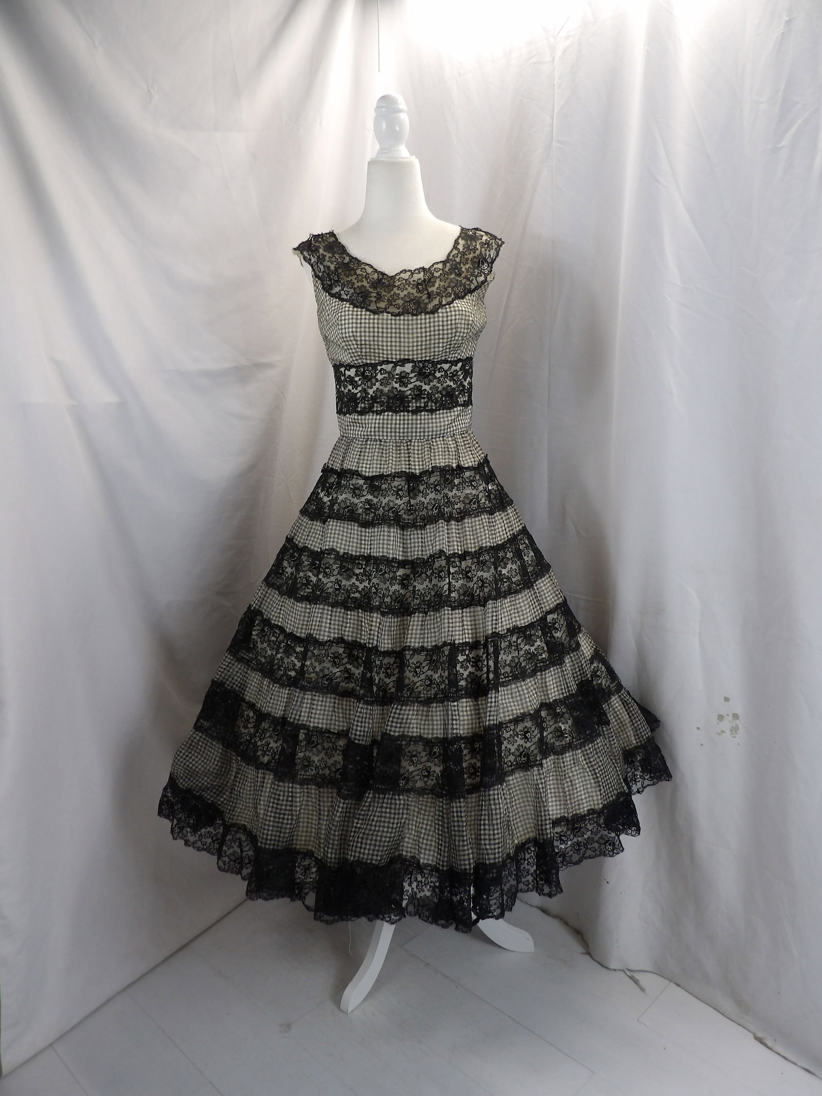 VINTAGE 1950'S BLACK & WHITE CHECKERED CIRCLE DRESS WITH BLACK LACE: APPROX. 36 BUST, 26 WAIST. NEEDS SEAM REPAIR BY UNDERARM & SHOULDERS. HAS A COUPLE OF SPOTS. SEE PHOTOS.