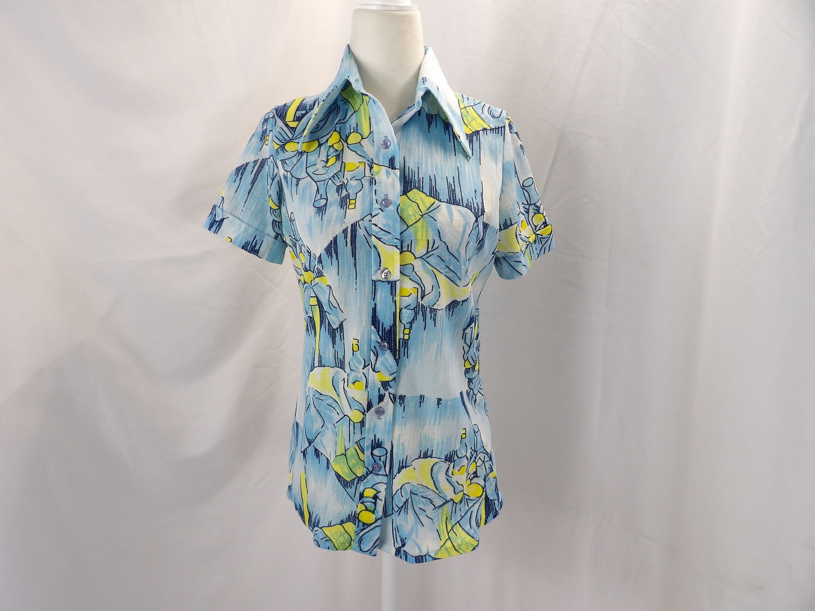 VINTAGE 1970'S TRISSI KNIT BLUE PICTURE BLOUSE: APPROX. 38 BUST, 34 WAIST. SLIGHT UNDERARM DISCOLORATION & PICKS IN FABRIC. SEE PHOTOS.