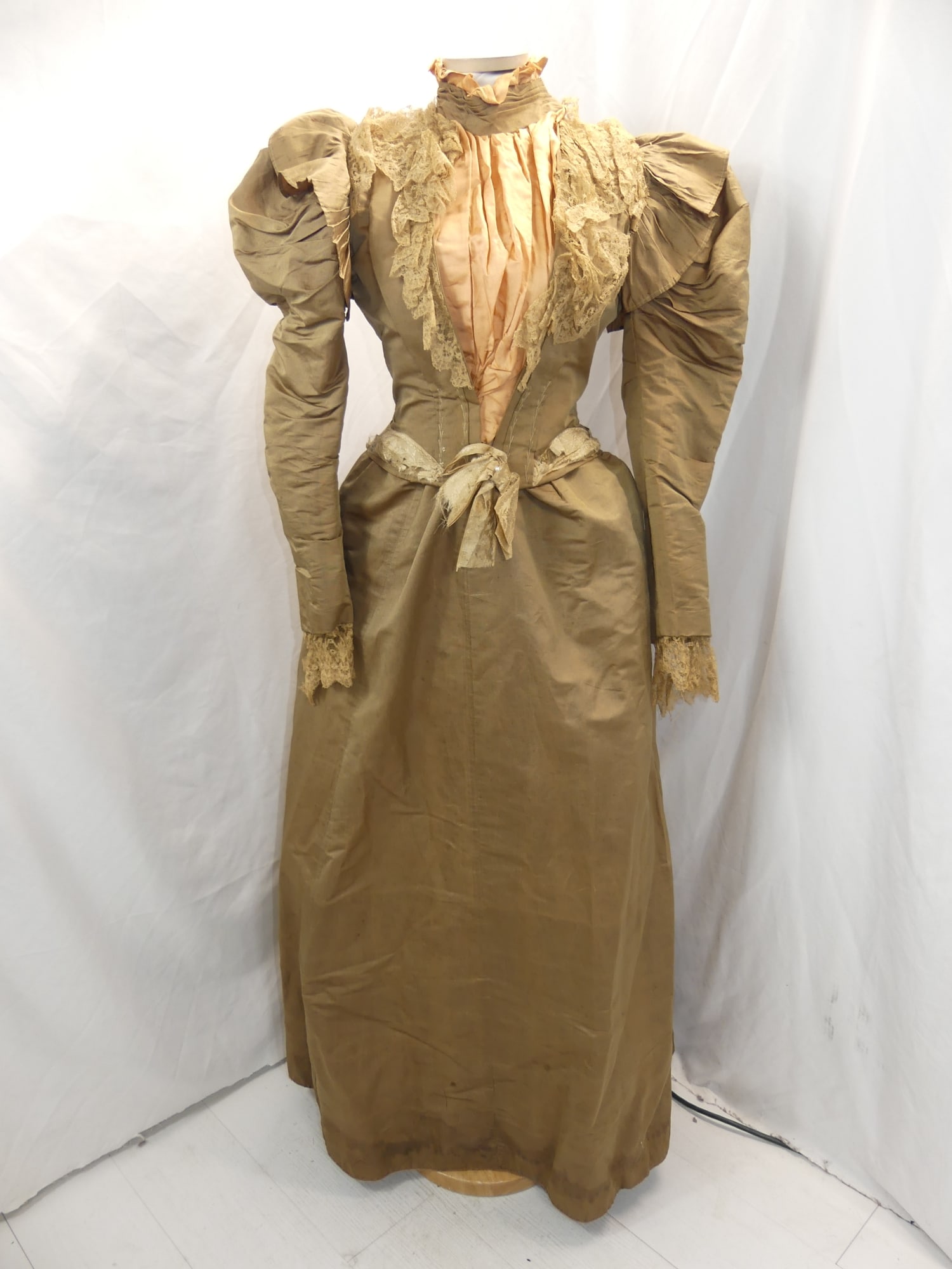 Antique 1800's Brown Faile Bustle Skirt & Bodice with Lace & Peach Silk trim: approx. 32 bust, 26 waist. Some underarm stains & damage. Has some holes in the lace & the silk ribbon at waist. Has fray at the waist of skirt. There is a water stained hem & a couple other small spo