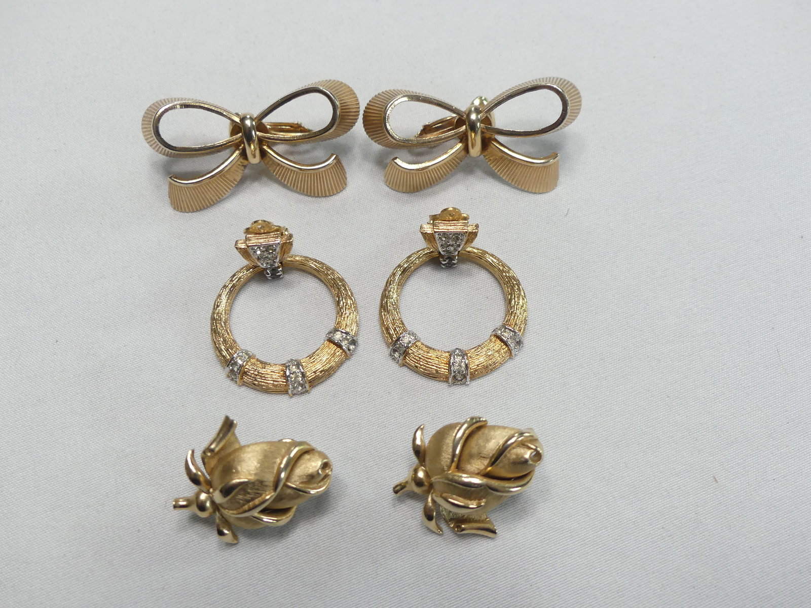 Three Pair Signed Vintage Earclips: 1 bow motif approx. 0.75" x 1.5" signed "Bartek"; 1 wreath approx. 1" x 1.5" stamped "Panetta"; 1 pair rose motif 0.75" x 1" stamped "Trifari"