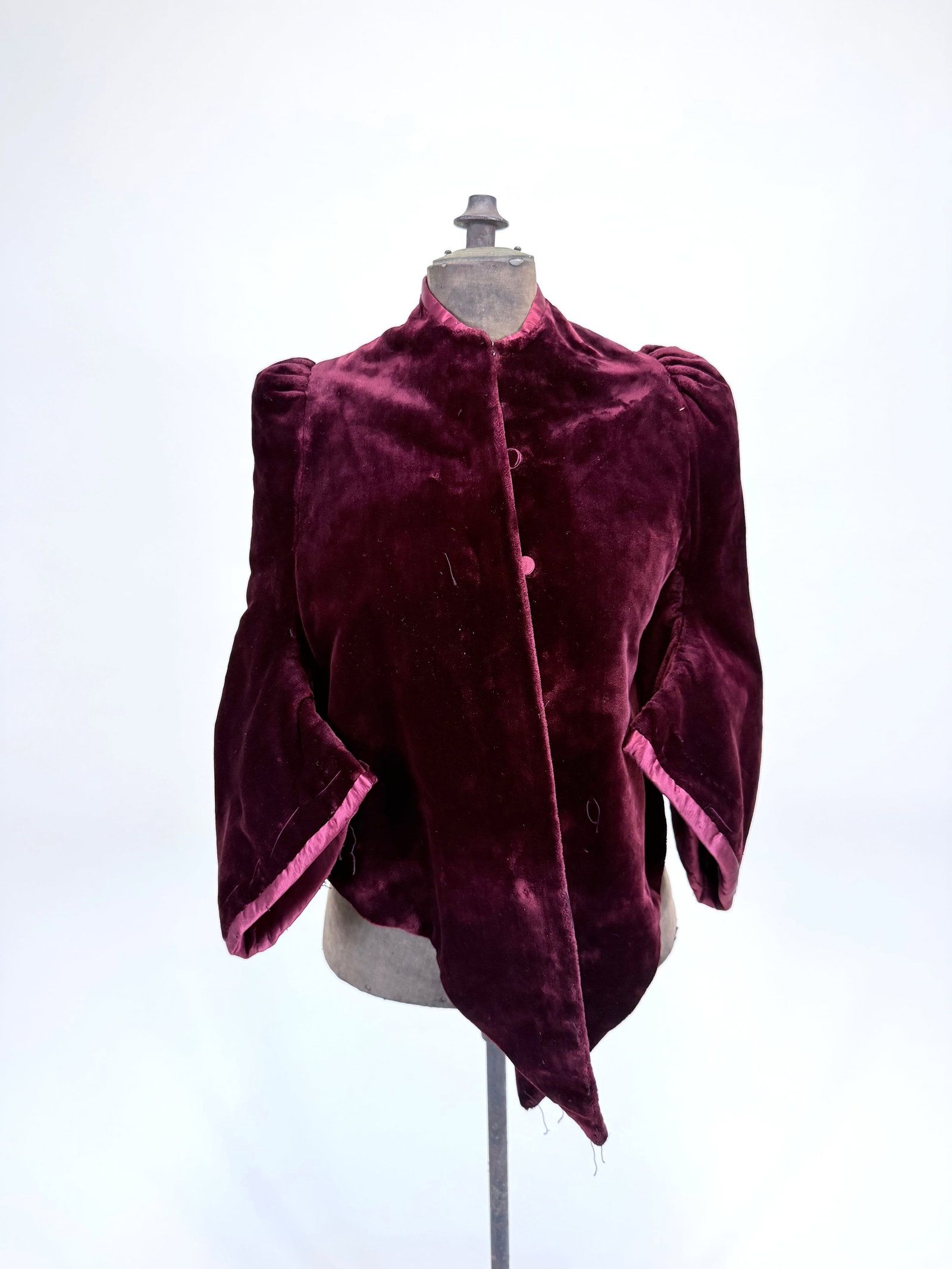 ANTIQUE CRIMSON SILK PLUSH DOLMAN JACKET, 1880s: SH-SH 17", L 19"-28", pulls & wear to collar, light crushing, missing elements at sleeves & front, see photos. Provenance: From the M. Estella Sprague Costume Collection