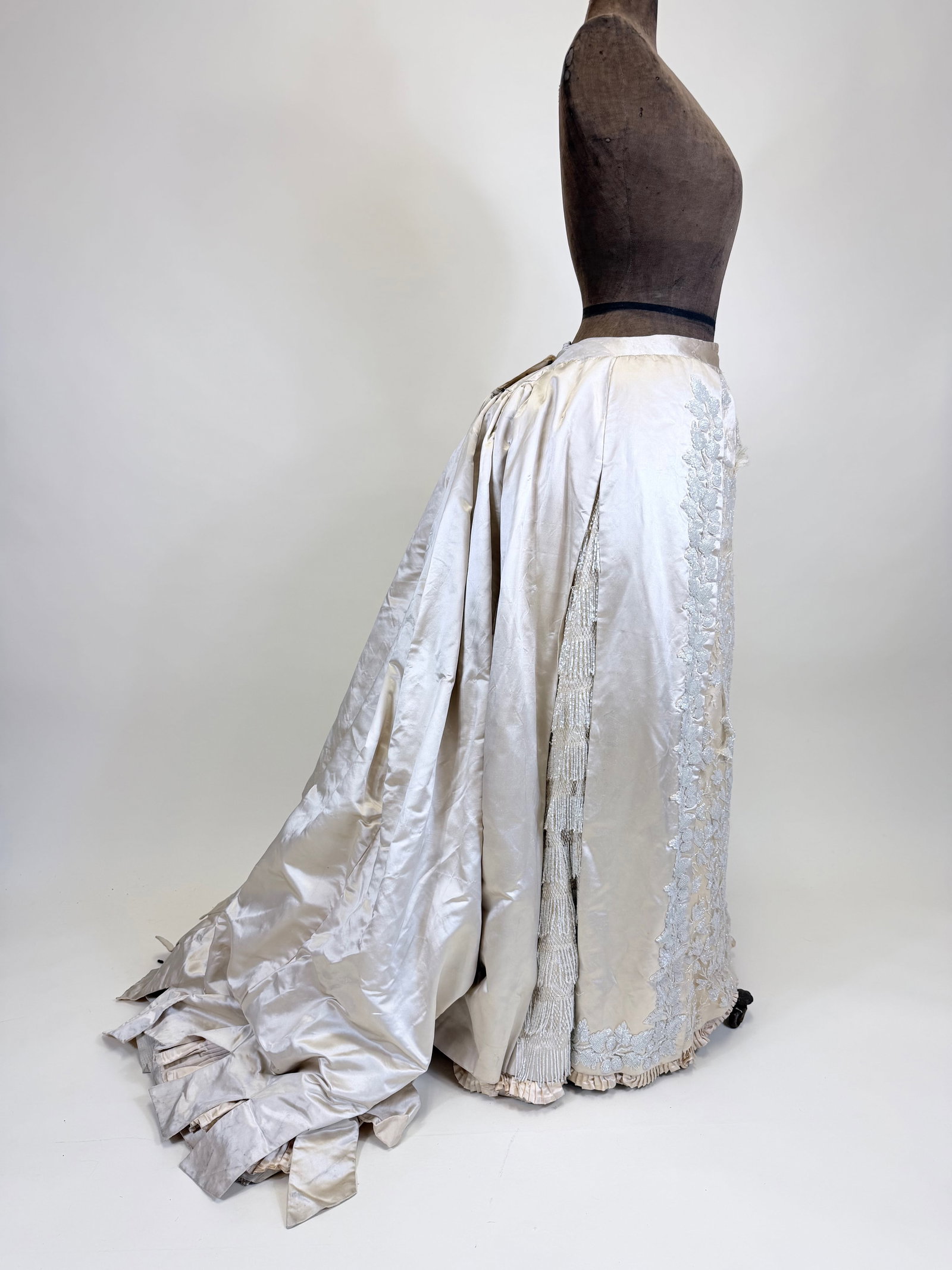 ANTIQUE HEAVILY BEADED SILK SATIN WEDDING OR EVENING SKIRT, 1890s: W 31", pulls to tulle, bead loss, t/w damaged 1880s silk satin bodice. Provenance: From the M. Estella Sprague Costume Collection