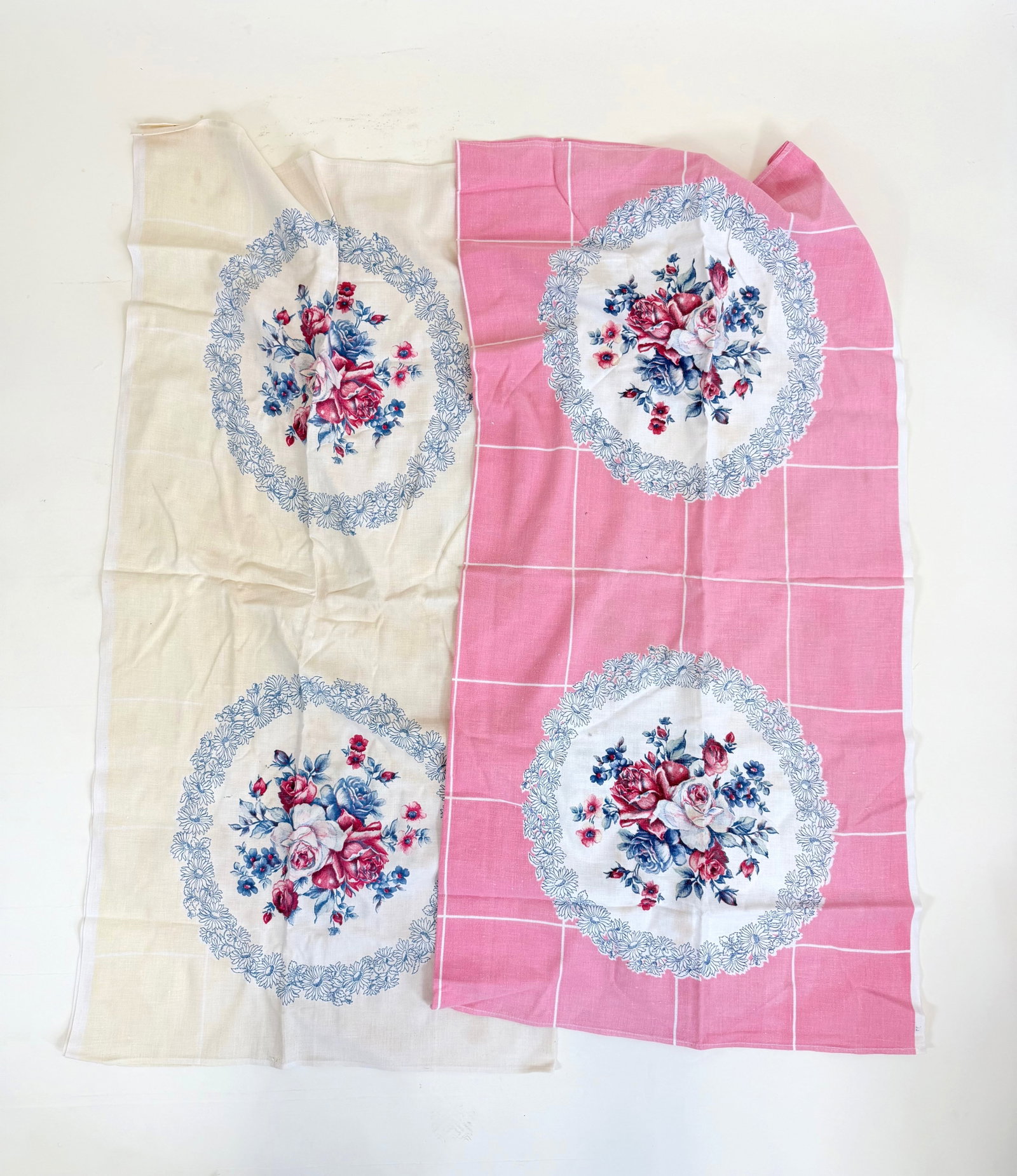 TWO FLORAL MOTIF TABLE COVERINGS, 1940s-1950s: Pink covering 49.5" x 48", spot stains, white 49.5" x 49.5", spot stains/discoloration, see photos