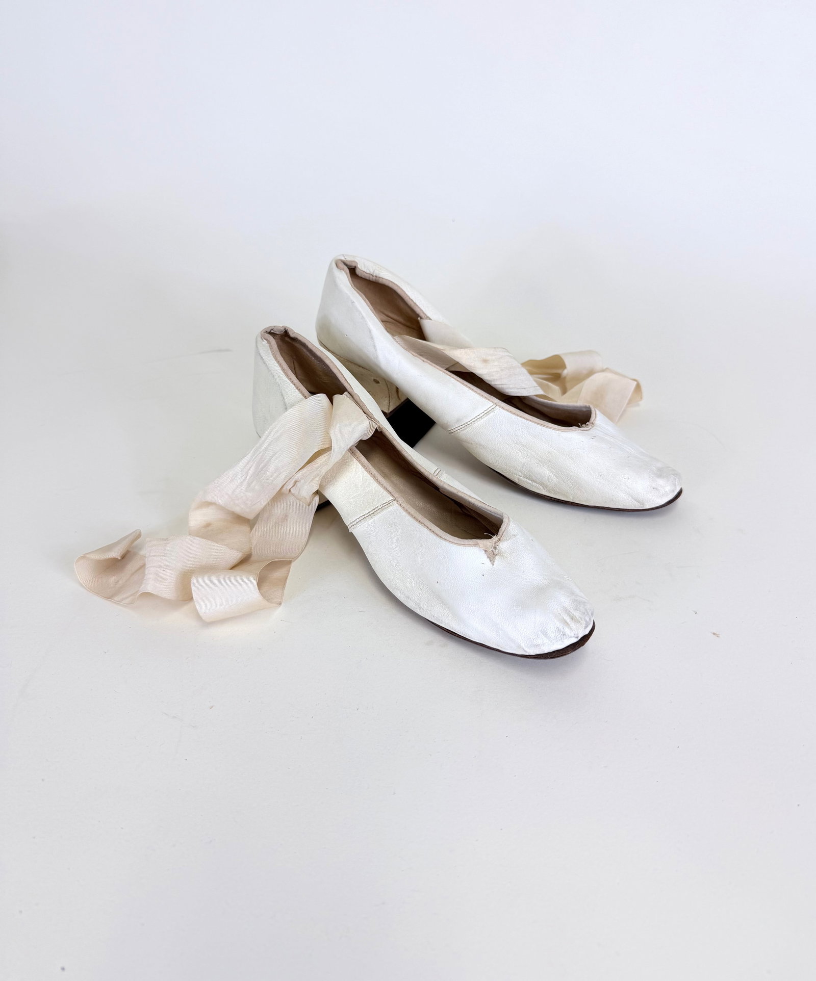 ANTIQUE IVORY KID LEATHER PUMPS, 1900-1920: Grosgrain ribbon added, staining & cracking to heel, tiny holes, see photos. Provenance: From the M. Estella Sprague Costume Collection