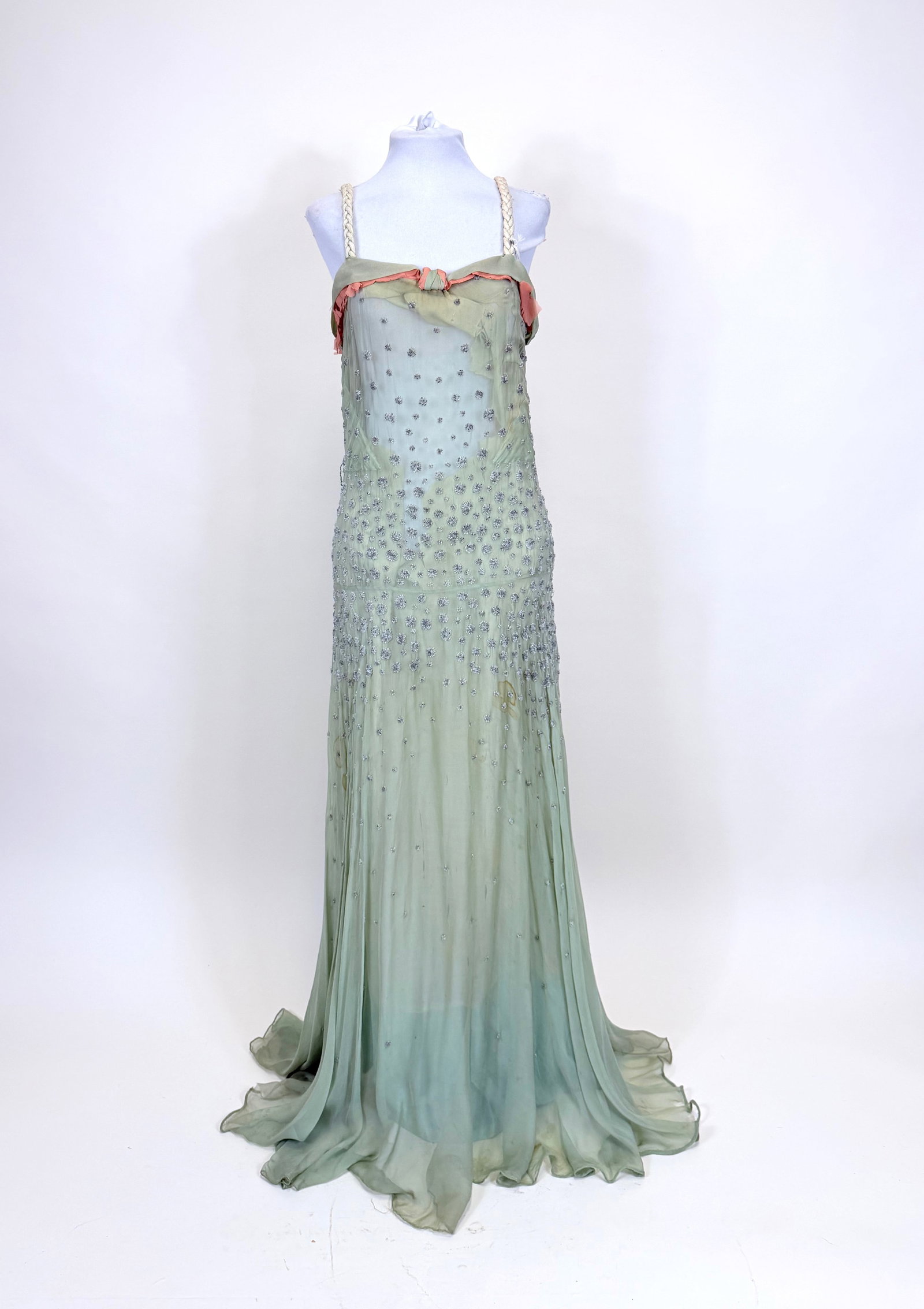 BEADED SEAFOAM SILK CHIFFON EVENING GOWN, 1930s: B 32", W 24", lining damaged, contrasting salmon colored chiffon damaged, spot stains to body of dress, see photos. Provenance: From the M. Estella Sprague Costume Collection