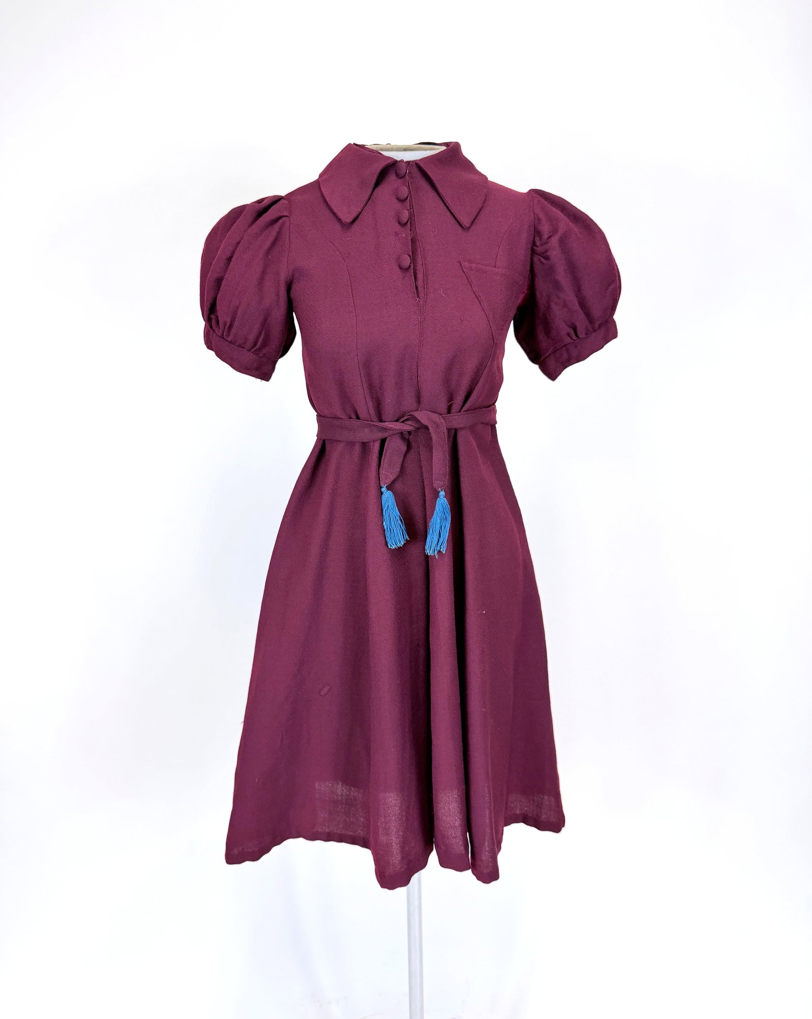 BURGUNDY KNIT GIRLS DRESS, 1940s: CH 30", W 34". Includes original tie belt. Fading & small holes underarms, some spot staining & pulls throughout skirt, see photos.
