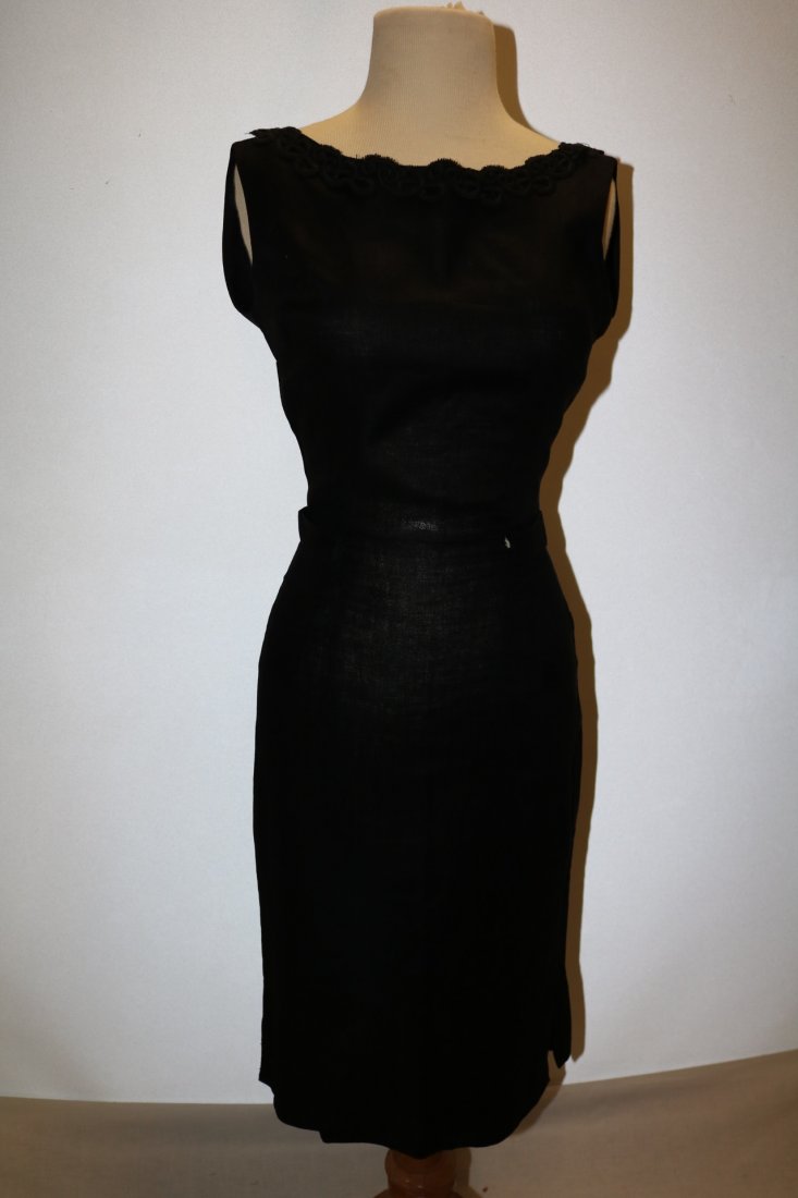 1960's Black Line Wiggle Cocktail Dress: silhouette fit, darts at waist, boat neck, trimmed in black decorative detail, plunging back with back belt (missing button) & back zipper, slight seam repair needed, approx. 36 bust, 26 waist