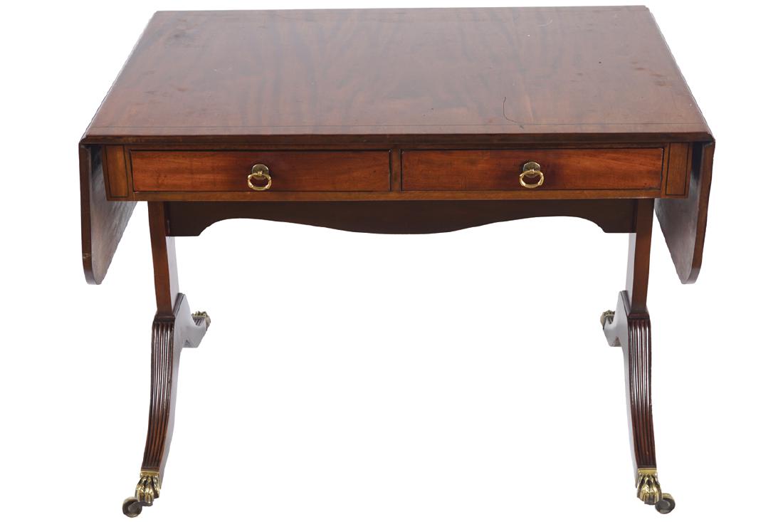 SIGNED WARING AND GILLOWS MAHOGANY AND EBONY STRING: the rectangular top, with drop leaves, above two frieze drawers, raised on panel and sabre ends, terminating on brass claw feet and casters Dimensions:94 cm. high; 66 cm. wide; 73 cm. deep (closed)