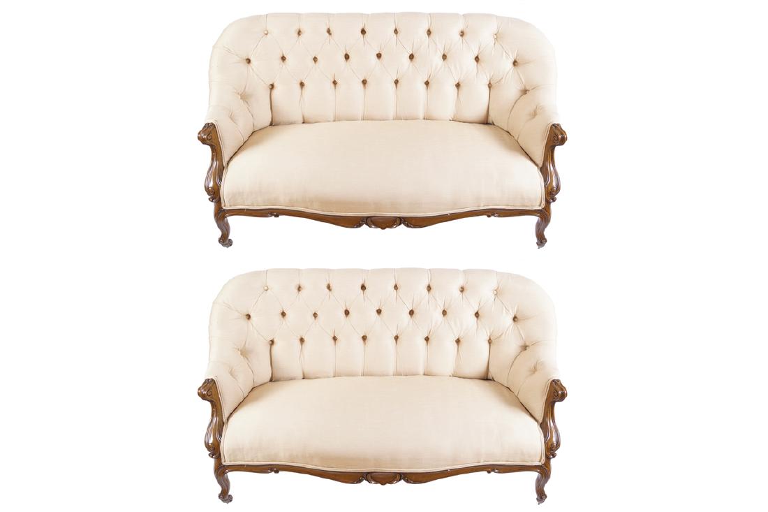 PAIR OF NINETEENTH-CENTURY WALNUT AND UPHOLSTERED: PAIR OF NINETEENTH-CENTURY WALNUT AND UPHOLSTERED SETTEES each with a deep buttoned upholstered back and scroll fronted arms, above a serpentine fronted seat and cabochon centred apron, raised on cabr