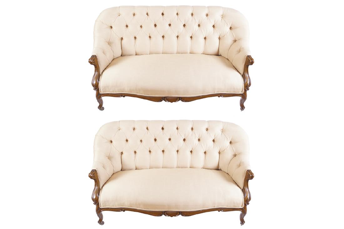 PAIR OF NINETEENTH-CENTURY WALNUT AND UPHOLSTERED: PAIR OF NINETEENTH-CENTURY WALNUT AND UPHOLSTERED SETTEES each with a deep buttoned upholstered back and scroll fronted arms, above a serpentine fronted seat and cabochon centred apron, raised on cabr