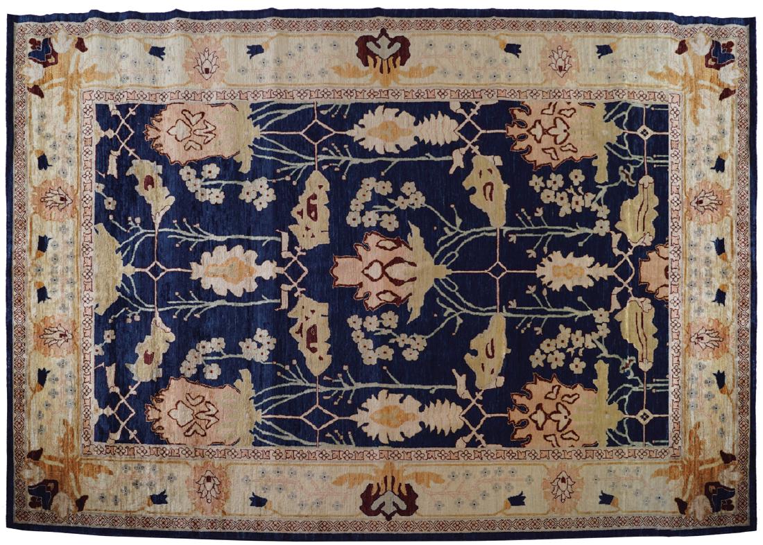 DONEGAL DESIGN CARPET, AFTER GAVIN MORTON AND G. K.: navy ground, with large and bold floral motifs, enclosed by an ivory and peach flower head border Measurements: 222 x 311 cm. (7.25 x 10.25 ft.) (approx.)
