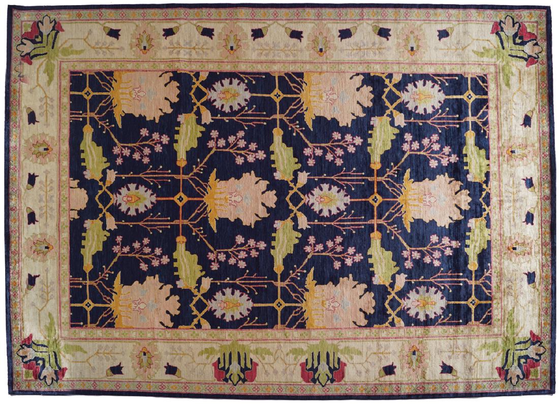 DONEGAL DESIGN CARPET, AFTER GAVIN MORTON AND G. K.: indigo ground, the field with alternating stylized peony flower heads, within in a cream lotus decorated border and indigo guard Measurements: 311 x 225 cm. (10.25 x 7.5 ft.) (approx.)