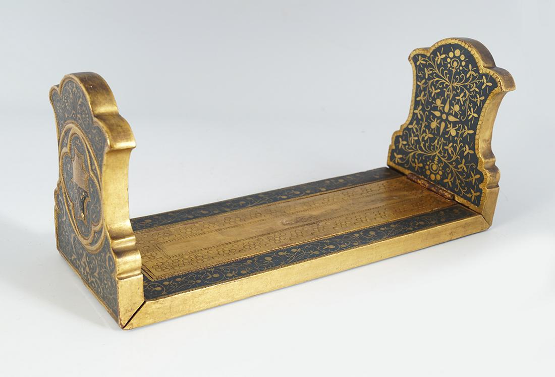 EBONY AND PARCEL GILT BOOK SLIDE: 19th-century 14 cm. h9gh; 32 cm. long