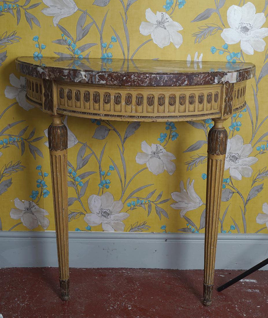 PAIR OF REGENCY PARCEL GILT CONSOLE TABLES: each with a breakfront demi lune shaped top, above a fluted frieze, raised on tapered turned and fluted legs to the fore 90 cm. high; 90 cm. wide; 45 cm. deep