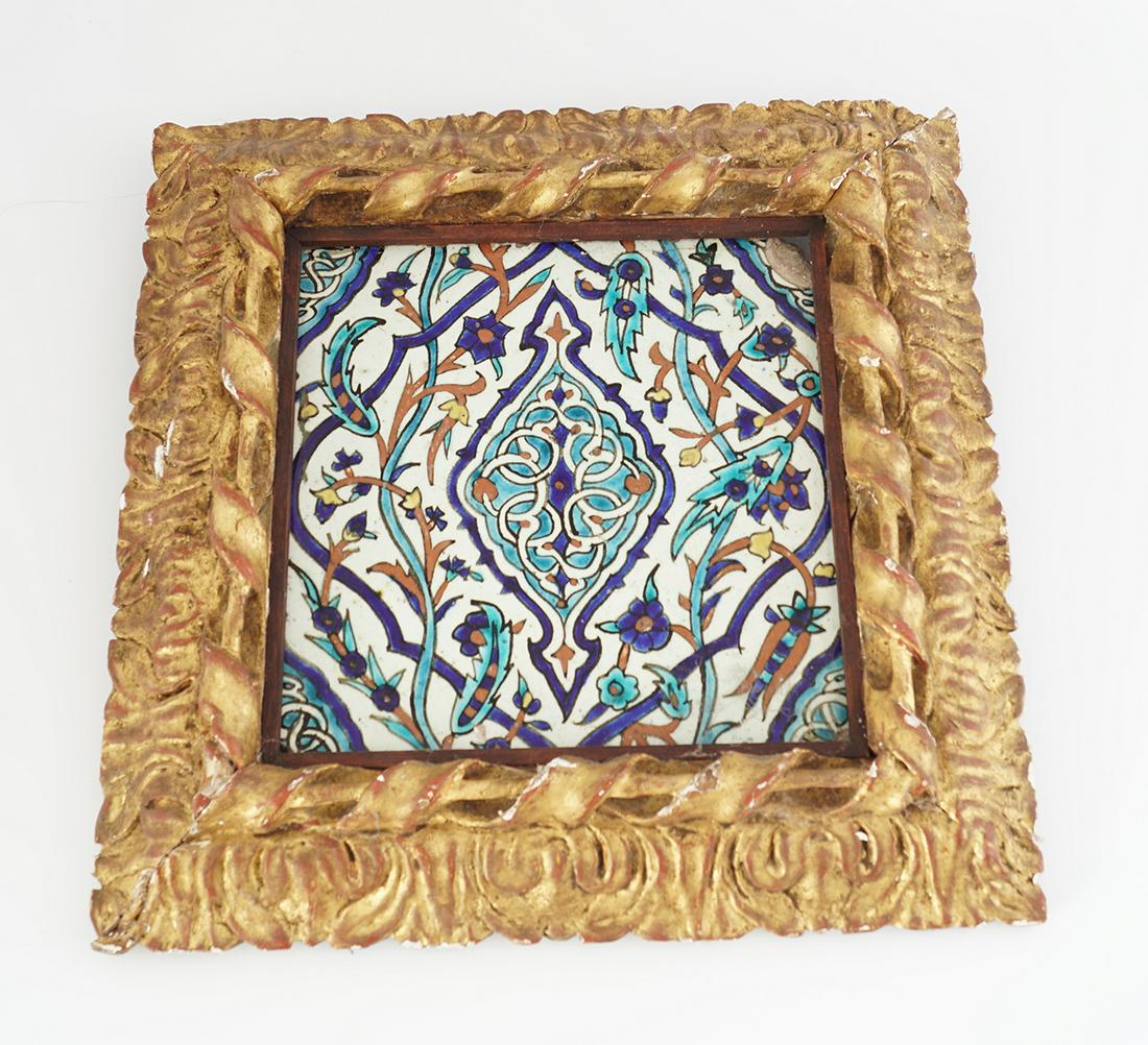 EARLY ISLAMIC POLYCHROME TILE: depicting leaf and floral buds, enclosed in an 18th-century carved giltwood frame Overall: 32 x 32 cm.