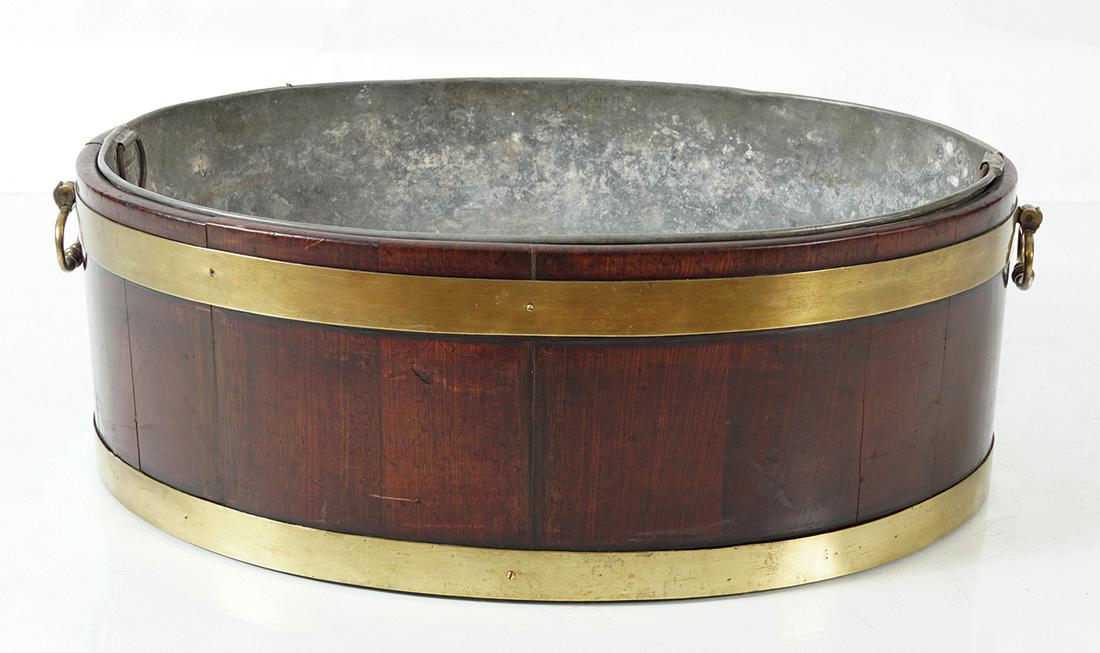 GEORGE III PERIOD MAHOGANY WINE COOLER: of oval brass bound form, furnished with brass carrying handles, circa 1790 60 cm. high; 60 cm. wide; 42 cm. deep (approx.)