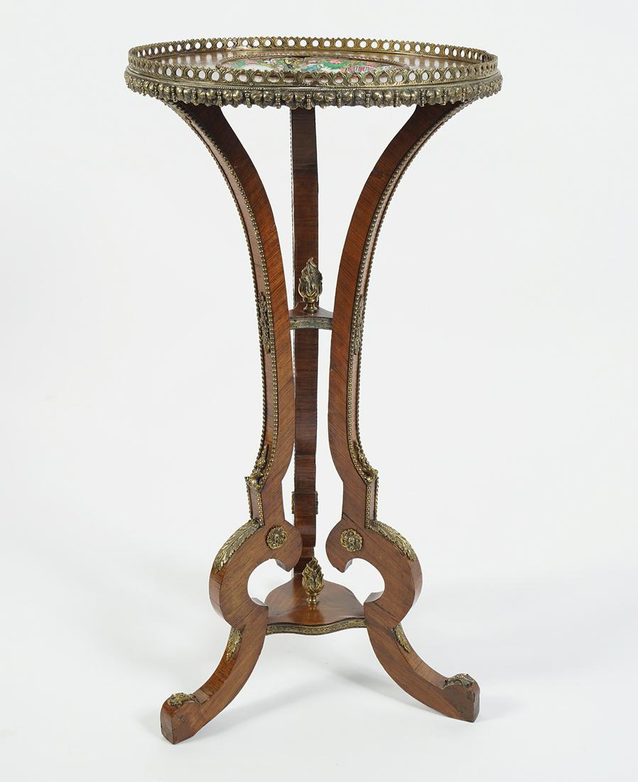 19TH-CENTURY KINGWOOD AND ORMOLU MOUNTED TABLE: the circular porcelain inset top raised on sweeping scroll legs joined by an undershelf 40 cm. diameter