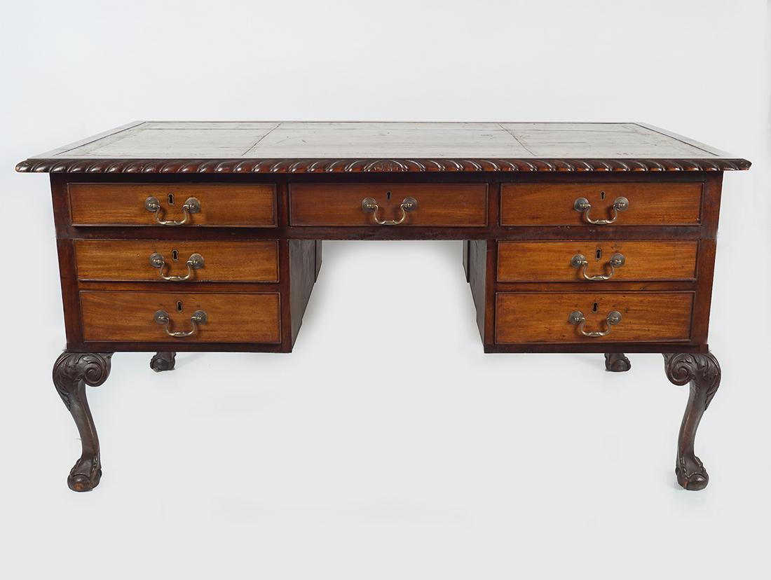 19TH-CENTURY MAHOGANY PARTNERS WRITING DESK: the rectangular tooled leather inset top with a gadrooned edge, above a series of seven drawers and opposing faux drawers on the other side, furnished with brass scroll handles, raised on acanthus lea