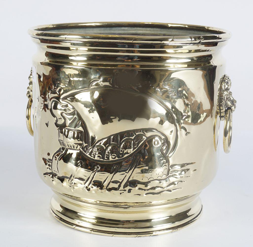 19TH-CENTURY BRASS ARMORIAL JARDINIERE: with repousse panelled body furnished with lion mask handles 24 cm. high; 26 cm diameter