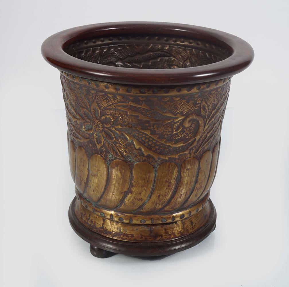 PAIR OF 19H CENTURY MAHOGANY AND BRASS LOG BARRELS: each of circular form, the body with spiral embossed decoration 44 cm. high; 43 cm. diameter