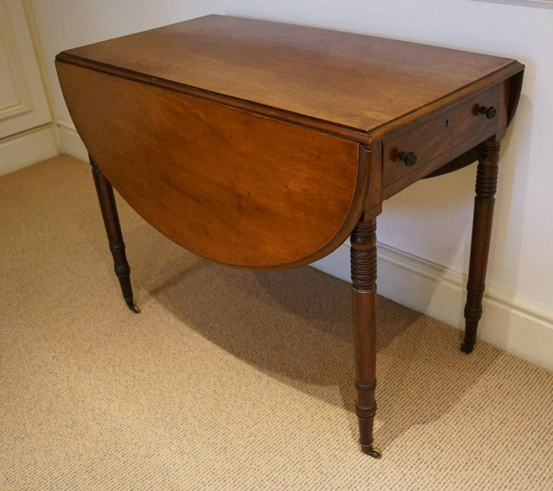 REGENCY MAHOGANY PEMBROKE TABLE: the rectangular shaped top with D-shaped drop leaves, above a real and opposing end drawer, furnished with turned wooden knobs, raised on turned legs terminating on brass leg castors. 71 cm. high; 91