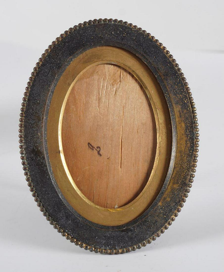 EDWARDIAN ORMOLU PHOTO FRAME: of oval form, with a beaded edge. 13.5 cm. high; 10.5 cm. wide