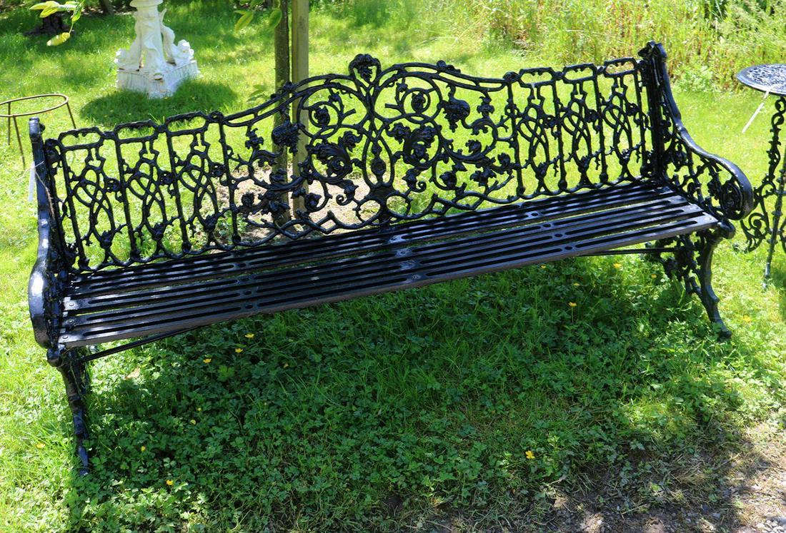 CAST IRON GARDEN BENCH: with intricately decorated leaf decorated panelled back, raised on scroll ends. 83 cm. high; 183 cm. wide; 60 cm. deep