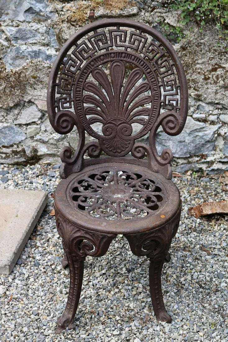 PAIR OF CAST IRON GARDEN CHAIRS: each with a scallop shaped back with Greek key scroll borders above a circular seat, raised on scroll legs. 82 cm. high; 40 cm. wide; 35 cm. deep