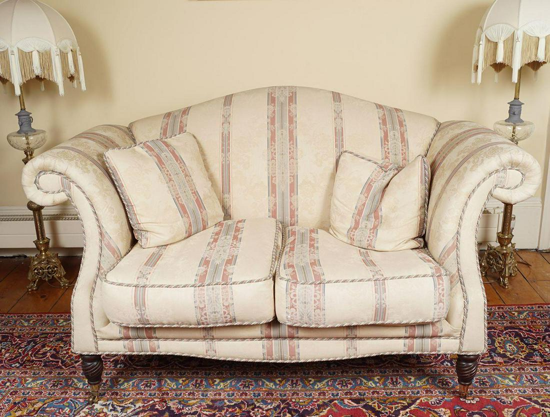 PAIR OF MODERN UPHOLSTERED HUMPBACK SETTEES: each with a loose cushioned seat raised on turned legs to the fore terminating on castors. 3-seater: 93 cm. high; 208 cm. wide; 79 cm. deep; 2-seater: 90 cm. high; 157 cm. wide; 83 cm. deep; Chair: 83