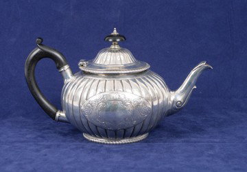 Silver tea pot: Silver tea pot, of reeded bulbous form, with leaf headed bird beak spout and ebony scroll handle, London 1885, Maker Charles Stuart Harris 500 grams
