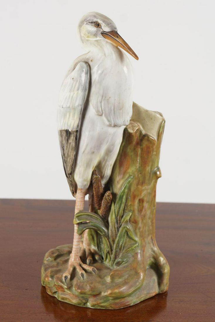 19TH-CENTURY MAJOLICA CRANE: Standing beside a tree trunk. 30 cm. high
