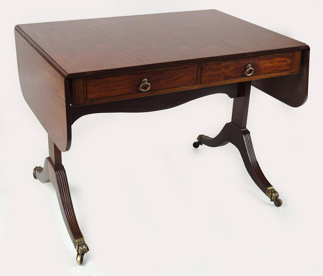 SIGNED WARRING & GILLOW SOFA TABLE: the rectangular shaped top with D-shaped drop leaves above two real and opposing drawers, raised on panelled and reeded sabre ends terminating on brass feet and castors.72 cm. high; 94 cm. wide; 66 cm