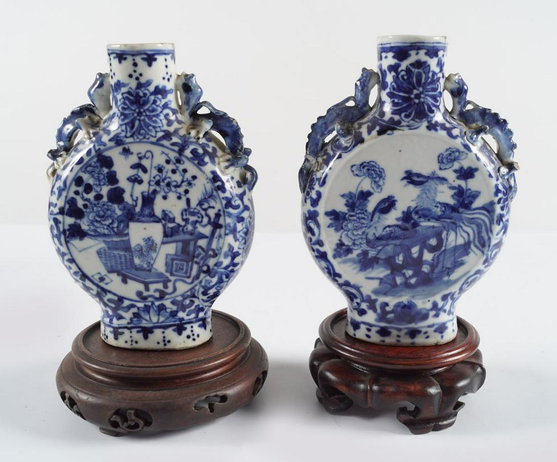 PAIR OF CHINESE QING BLUE & WHITE VASES: each of moon flask shape with chilong scroll handles, and still life panels.Provenance: The Collection of the late Dr. Jan Mohamed, Pouldrew House, Co. Waterford. 14.5 cm. high(Lot 1100)