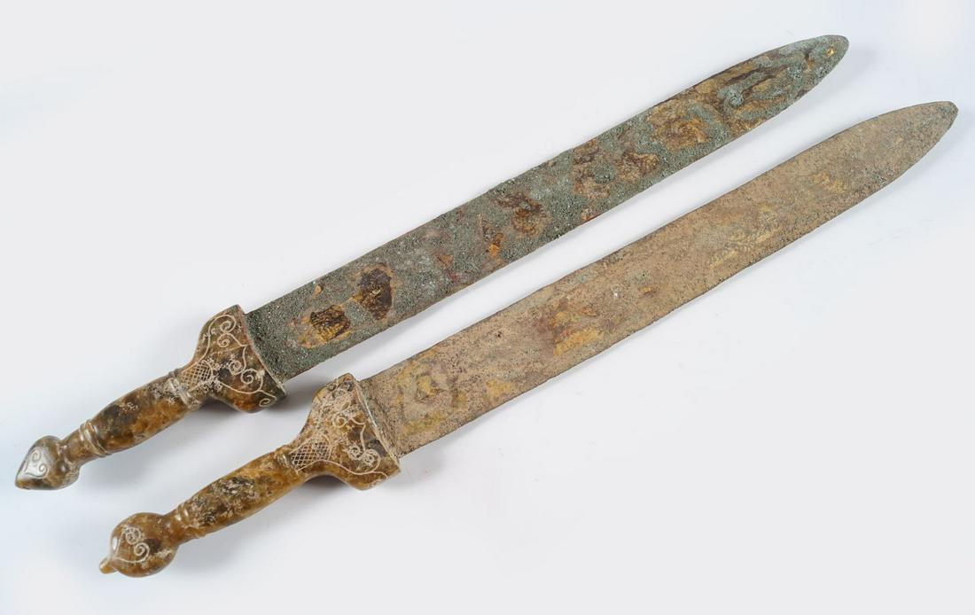 2 CHINESE ARCHAIC GILT BRONZE DAGGERS: each with a jade handle.Provenance: The Collection of the late Dr. Jan Mohamed, Pouldrew House, Co. Waterford. 43 and 44 cm. long(Lot 1567)