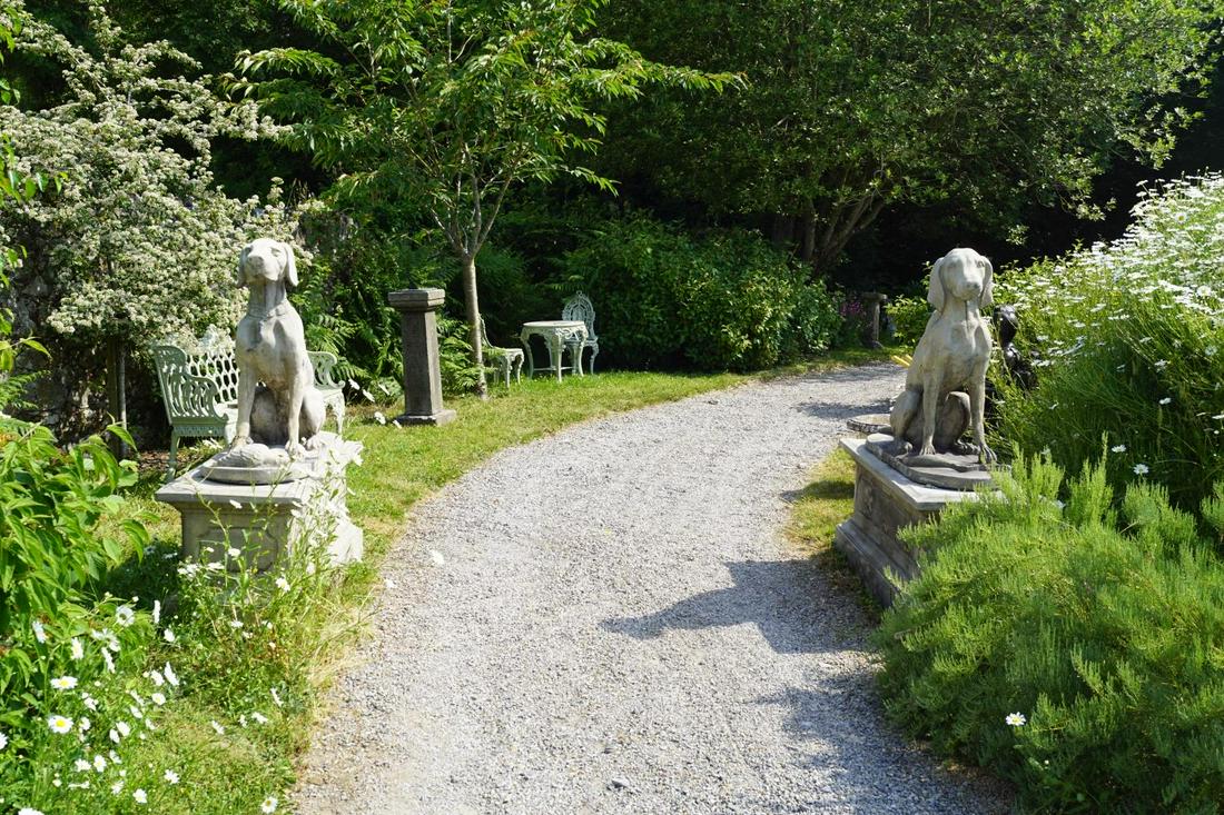 PAIR OF LARGE ITALIANATE STONE GUN DOGS: After Henri Alfred Jacquemart, each mounted on a square panelled plinth. Approximate Time: 10:36 Lot No: 41 Category: Garden & Decorative Objects
