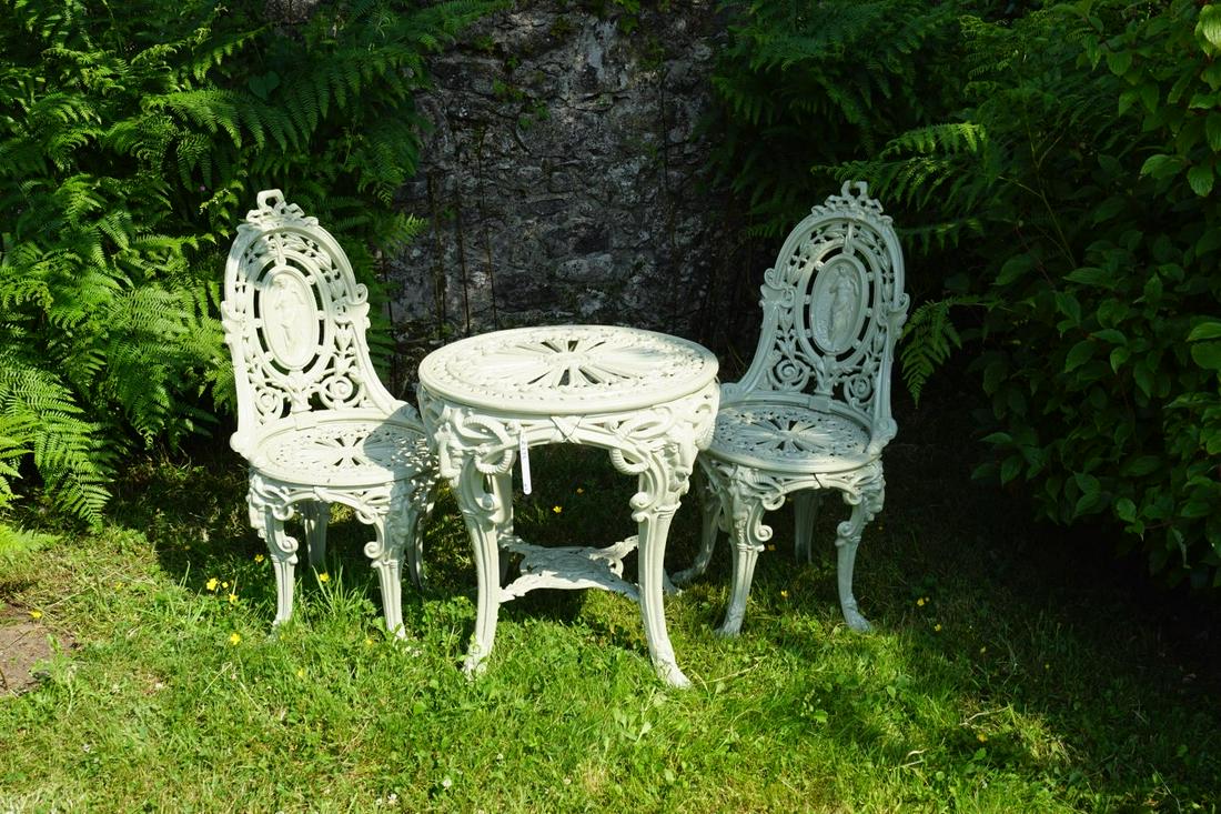ROCOCO CAST IRON GARDEN TABLE: and 2 cameo backed chairs, each raised on ram's head mask decorated scroll legs. Approximate Time: 10:39 Lot No: 45 Category: Garden & Decorative Objects