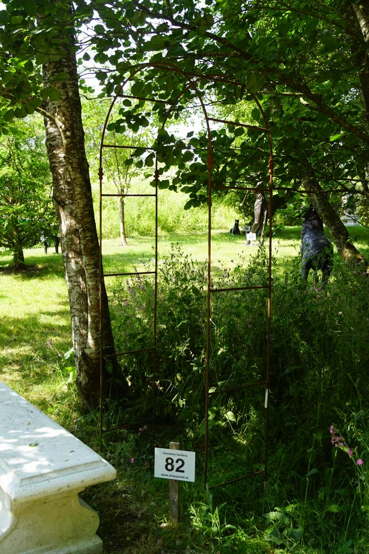 WROUGHT IRON GARDEN ARCH: raised on panelled ends. 245 cm. high; 100 cm. wide Approximate Time: 11:12 Lot No: 82 Category: Garden & Decorative Objects