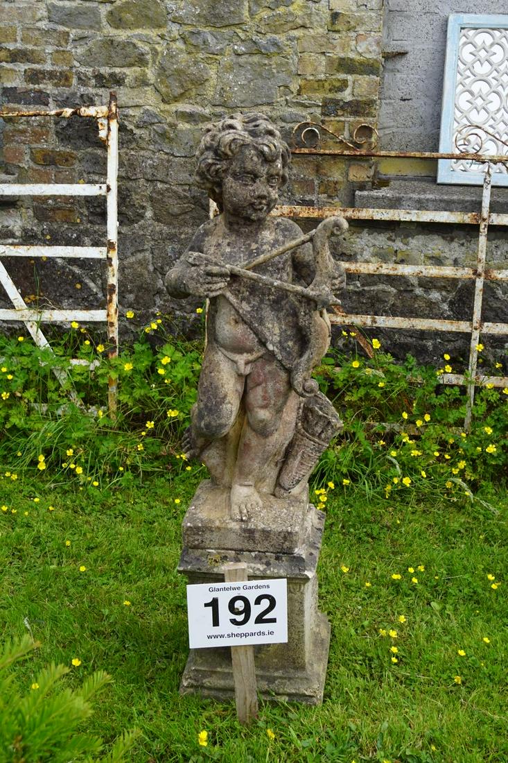 ITALIANATE STONE GARDEN SCULPTURE: Figure of a cherub with a bow and arrow, raised on a square plinth. Approximate Time: 12:51 Lot No: 192 Category: Garden & Decorative Objects