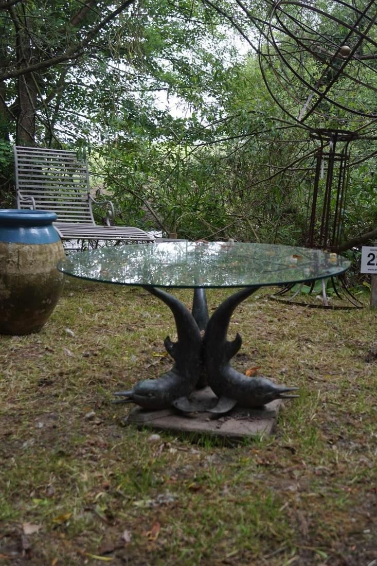 EARLY 20TH-CENTURY BRONZE GARDEN TABLE: the circular glazed top, supported on 3 dolphins. 47 cm. high; 55 cm. diameter Approximate Time: 14:34 Lot No: 239 Category: Garden & Decorative Objects