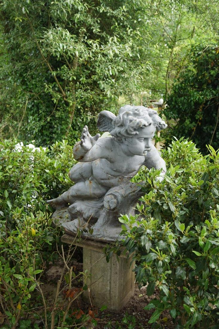 19TH-CENTURY CAST IRON WINGED CHERUB: resting on a rock. 80 cm. high; 90 cm. long Approximate Time: 15:09 Lot No: 278 Category: Garden & Decorative Objects