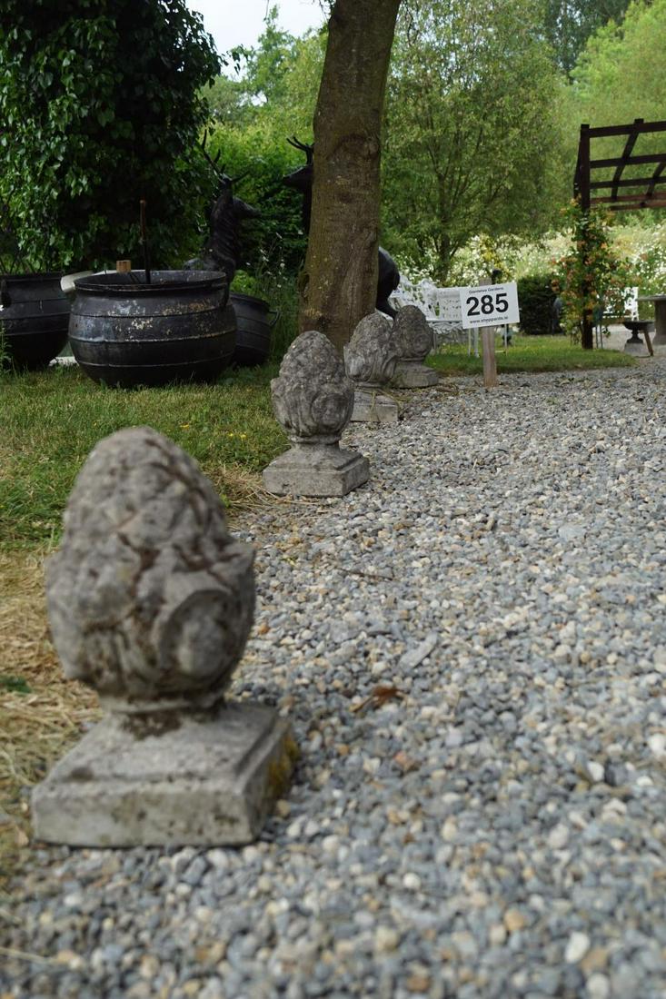 GROUP OF FOUR WEATHERED COMPOSITE STONE ACORNS: each with a square base. 30 cm. high; Approximate Time: 15:15 Lot No: 285 Category: Garden & Decorative Objects